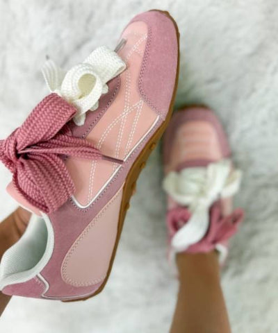 Pink shoes with white flowers on a soft white background